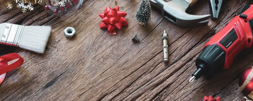 Prezent dla mężczyzny - narzędzia leżące na drewnianym blacie i świąteczne ozdoby